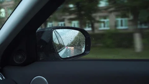 Reflection in car rear mirror while driving in city streets, POV 動画素材 292456929