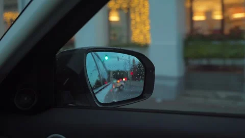 Reflection in car rear mirror while driving in city streets, POV 動画素材 292457066