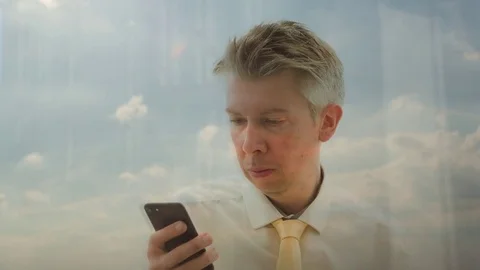 Reflection of a Caucasian businessman using smartphone Video stock 80741151