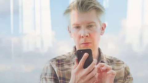 Reflection of a Caucasian looking at his smartphone Video stock 80759577