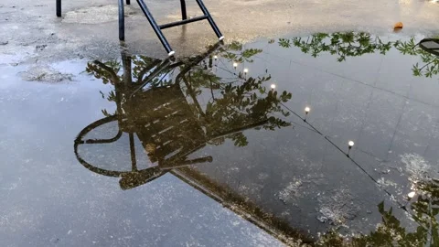 Reflection of a Chair and Tree in a Clear Puddle Outdoors Stock Footage 304617043