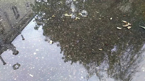 The reflection of the city and the man in the puddle. Stock Footage 112368501