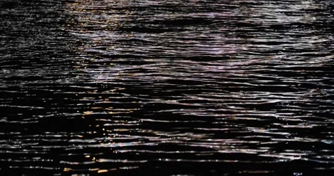 Reflection of city lights at night on the wavy sea. Stock Footage 247504840