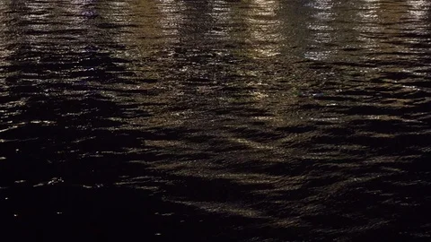 The reflection of city lights in the water of the river in the night Stock Footage