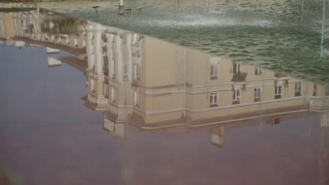 Reflection of the city in a puddle in summer. Camera in motion 스톡 동영상 318977168
