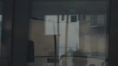 Reflection of cityscape in windows of moving tram or long bus on cloudy day Stock Footage 314016514