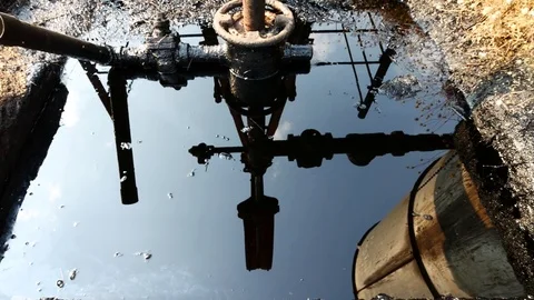 Reflection of Close up Oilfield Christmas Tree and Oil Pump Jack Stock Footage 74780260