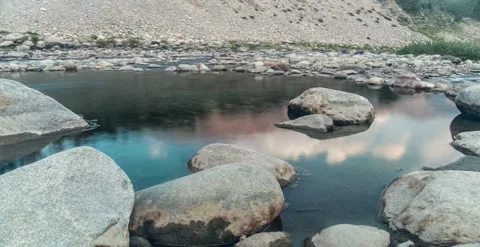 Reflection of clouds and mountain on water in a natural pond timelapse  Видео 247132486