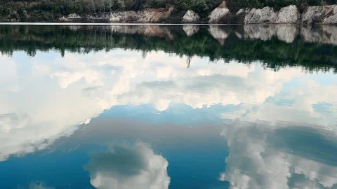 Reflection of clouds in a blue lake with shores Stockbeeldmateriaal 129728374
