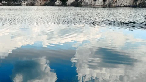 Reflection of clouds in a blue lake with shores Stock Footage 129728396