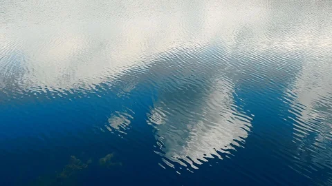 Reflection of clouds in a blue lake with shores Stockbeeldmateriaal 129728420