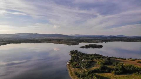 Reflection of clouds in the lake. Beginning of sunset. Stock Photos