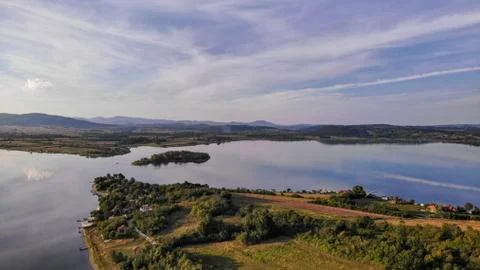 Reflection of clouds in the lake. Beginning of sunset. Stock Photos