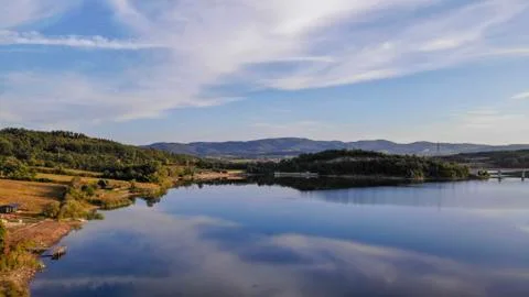 Reflection of clouds in the lake. Beginning of sunset. Stock Photos