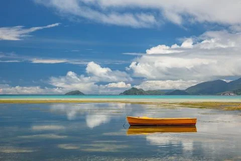 Reflection of clouds in the water and a boat on a tropical island Foto stock