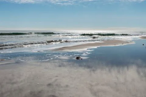 Reflection of the clouds in the water of the beach Stock Photos