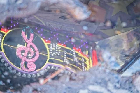 Reflection of colorful neon music notes and treble clef sign in water puddle Stock Photos