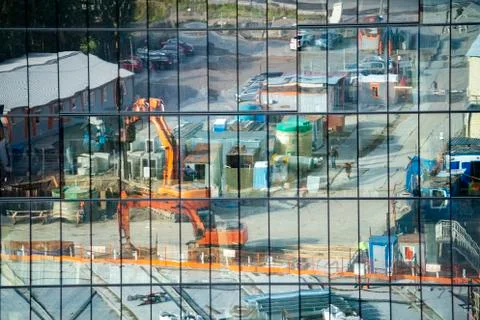 Reflection of the construction site in the glass facade Stock Photos
