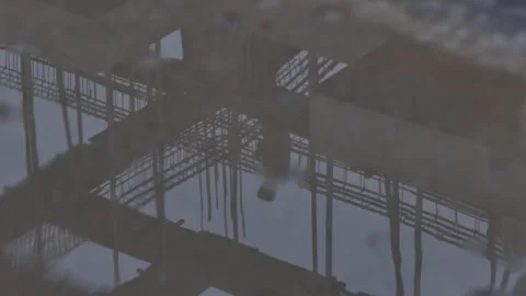 Reflection of construction worker in puddle on building site Stock Footage 317821688