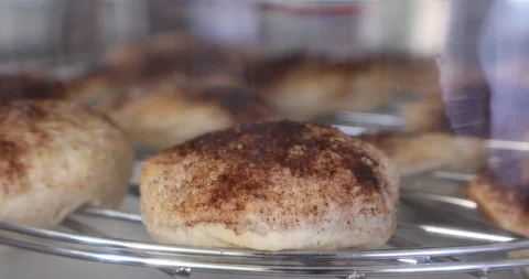 Reflection of a cook watching how puff pastry rises in an electric blown oven Stock Footage 129002819