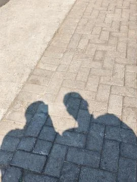 The reflection of a couple on the cobblestone street Stockfoto's