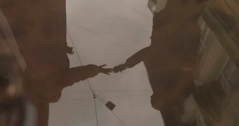 Reflection of a couple in love in a puddle of rainwater on the asphalt Stock Footage 247487274