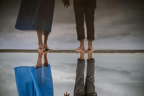 Reflection of Couple Standing on Beach Shore Stock Photos