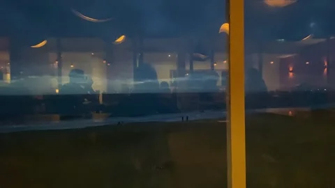 Reflection in the dark glass of a cafe window on the ocean shore Stock Footage 260426581
