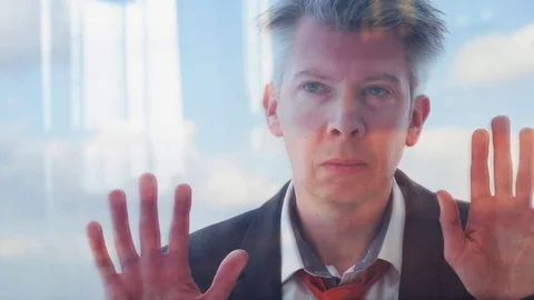 Reflection of a daydreaming businessman looking out of a window Video stock 80689357