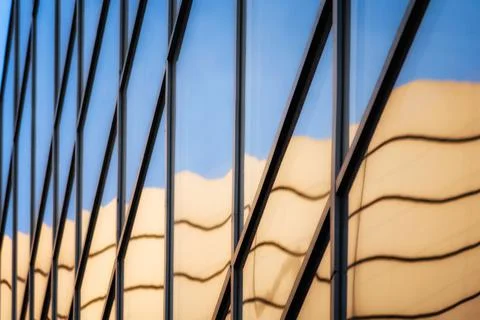 Reflection with distortion in the window of a modern tall building Stock Photos