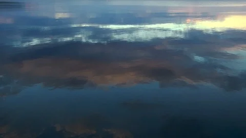 Reflection of evening clouds on the sea surface. The span of the drone above the Stock Footage 104575279
