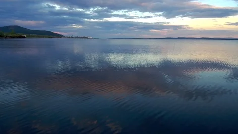 Reflection of evening clouds on the sea surface. The span of the drone above the Stock-Footage 104575533