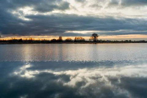 The reflection of the evening clouds in the water of a lake Stock Photos