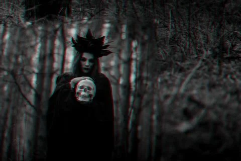 Reflection of an evil scary witch with a dead man's skull in a mirror 스톡 사진