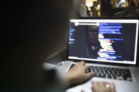 Reflection of female hacker coding working hackathon at laptop Stock-Fotos