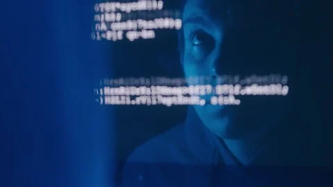 Reflection of a female hacker on a computer screen displaying code Stock Footage 279181833