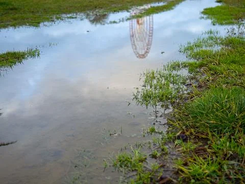 Reflection of a ferris wheel in a puddle. Resort town after the rain. Batum.. Stock Photos
