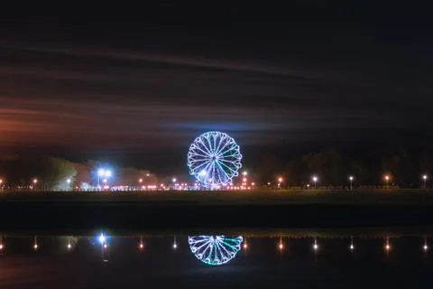Reflection of the Ferris wheel in the water on a spring night in the Oka pear Stock Photos