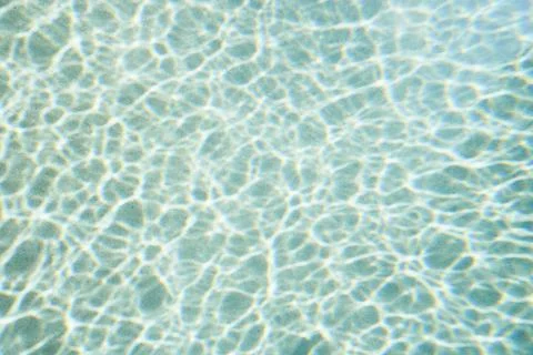 Reflection forming pattern over blue swimming pool water Stockfoto's