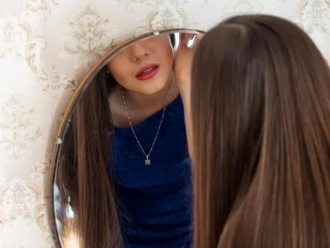 Reflection of a girl in a mirror that does makeup.Red lips Stock-Fotos