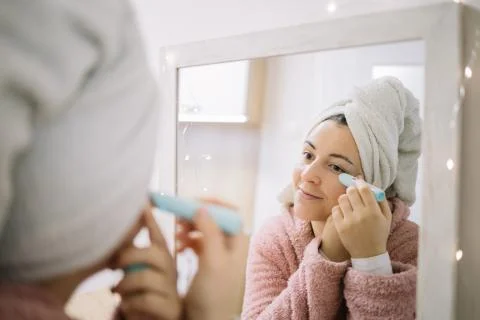 Reflection of a girl using eye wrinkle eraser Stock Photos