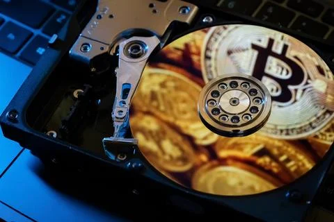 Reflection of gold coins of the cryptocurrency on the hard disk Stock Photos