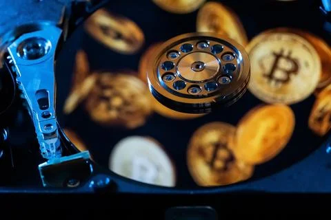 Reflection of gold coins of the cryptocurrency on the hard disk Stock Photos