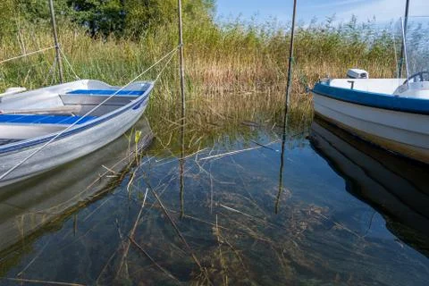 Reflection in green water between two small boats in a lake. Picture from Stock Photos