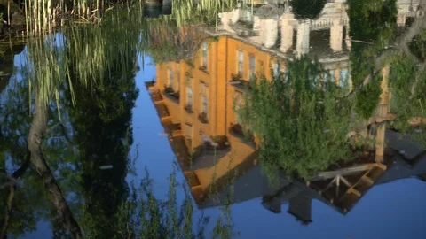 Reflection of a house in the blue water of a lake. Rural abstract landscape Stock Footage 107444792