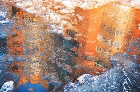 Reflection of a house in an ice puddle in spring. Melting snow. Foto stock