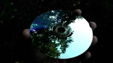 Reflection of the image of the wood, the sky, volcano from the disk DVD Stock-Footage 11846831