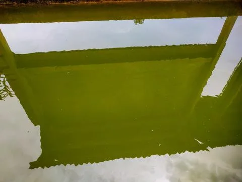 Reflection of an information board and sky on a cloudy pond Stock Photos