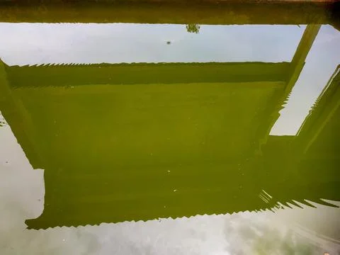 Reflection of an information board and sky on a cloudy pond Stock Photos