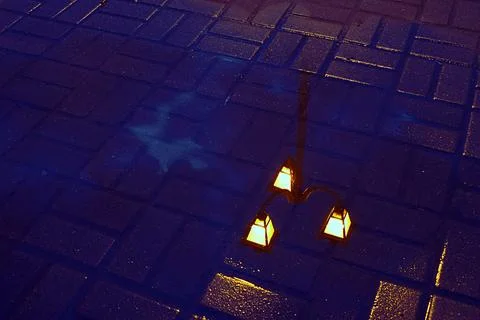 Reflection of a lantern in a puddle. Stock Photos